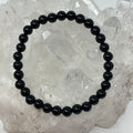 6mm polished black tourmaline round bracelet by World Wide Gems Minerals Beads, featuring smooth black gemstone beads.