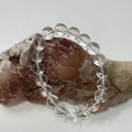 Crystal Quartz 10mm round bracelet by World Wide Gems Minerals Beads featuring polished quartz beads on an elastic band.
