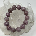 Lepidolite 14MM round gemstone bracelet from World Wide Gems Minerals Beads, featuring polished lavender-colored stones.