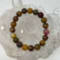 Mookaite 10mm round gemstone bracelet by World Wide Gems Minerals Beads, featuring polished, natural Mookaite beads on an elastic band.