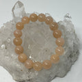 Peach aventurine 12mm round gemstone bracelet by World Wide Gems Minerals Beads, featuring smooth, polished peach-colored stones.