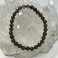 Set of two 6mm smoky quartz round gemstone bracelets by World Wide Gems Minerals Beads, showcasing polished beads.