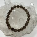 Smoky Quartz 8mm round gemstone bracelet by World Wide Gems Minerals Beads featuring polished beads on a stretchy cord.