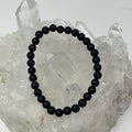 Matte black 6mm round Tourmaline bracelet from World Wide Gems Minerals Beads, featuring polished gemstone beads on an elastic band.