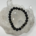 Black Golden Sheen Obsidian 8mm round bracelet with polished beads, showcasing a glossy finish and natural gemstone appearance.