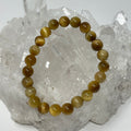 Two 8mm honey tiger eye round gemstone bracelets from World Wide Gems Minerals Beads, showcasing warm, polished stone beads.