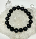 Black Tourmaline 12mm round bracelet from WorldWideMinerals-beads, featuring polished black gemstone beads on a flexible elastic band.